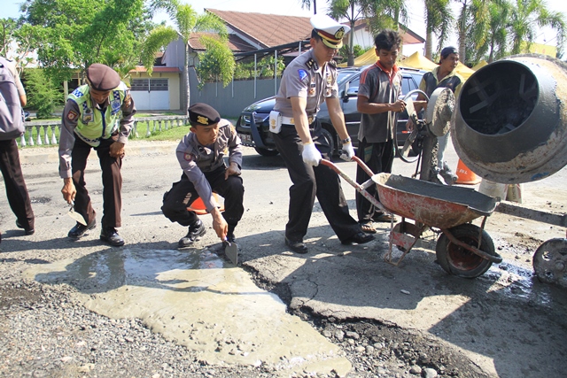 Polisi Tambal Jalan Berlubang