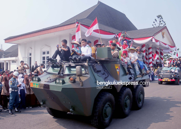 Warga menaiki kendaraan tempur Anoa TNI yang mengikuti parade alutsista (Alat utama sistem senjata) dalam kegiatan peringatan HUT ke-78 TNI di Lapangan Balai Semarak Bengkulu, Kamis (5/10/2023). Foto Rio Susanto/Bengkulu Ekspress